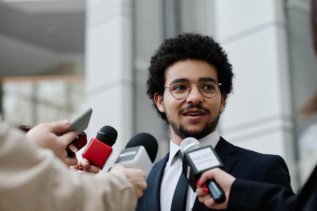 Man being interviewed by reporters