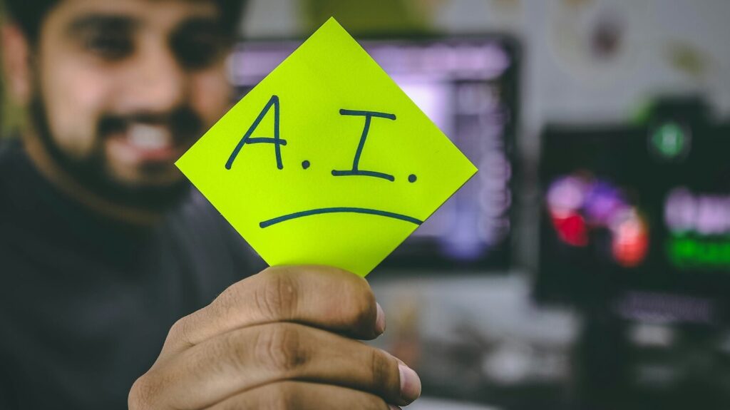 Man holding sticky note with AI written on it